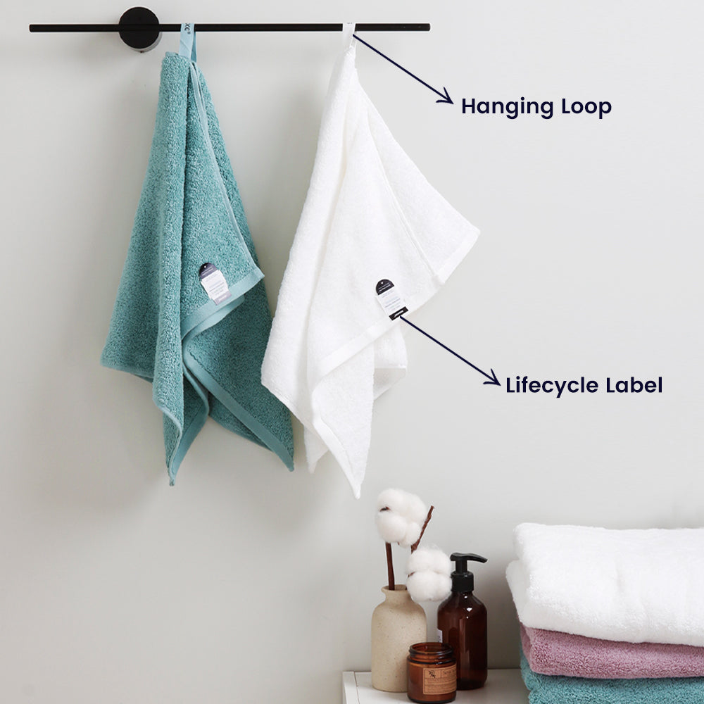The blue and white towel hangs on the towel to catch off showcasing its unique hanging loop and life cycle label