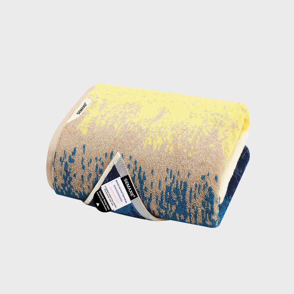 This SEMAXE Beach Series Bath Towel Set features a beautifully designed bath towel with an intricate blend of yellow, beige, and deep blue patterns, evoking the vivid hues and dynamic textures of a beachscape. Made from 100% pure cotton, the towel promises exceptional softness and durability, perfect for enhancing your bathing experience.