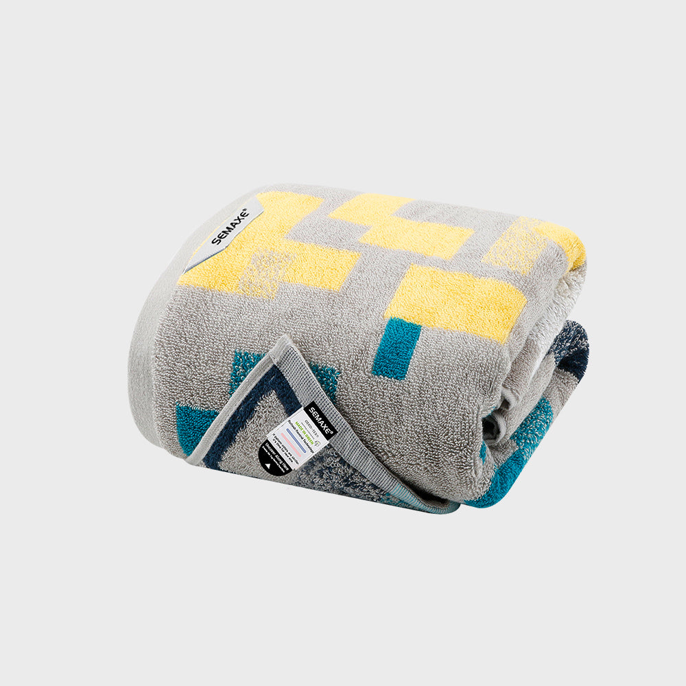 Step into a world of abstract beauty with the SEMAXE Impression Bath Towel. Crafted with precision from the finest cotton, this towel showcases a striking pattern of grey, yellow, and blue blocks, reminiscent of an artist's careful strokes on a canvas. Its plush texture offers superb absorbency and a gentle touch, making every bath feel like an escape into a piece of modern art. Ideal for enhancing the style and comfort of any bathroom decor.