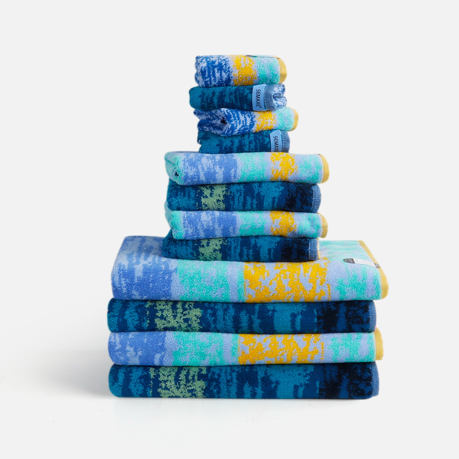 A 12-piece bath towel set, neatly arranged on a flat surface, with an artistic pattern inspired by Van Gogh's painting "Starry Night"