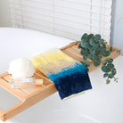 Hand towels from the beach series are folded and placed on the bathroom shelf to create a relaxing shower atmosphere