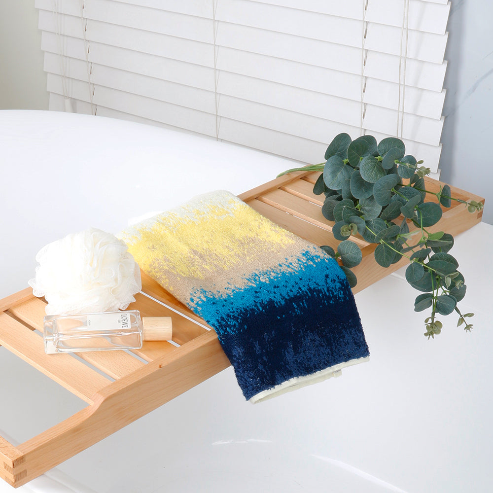 Hand towels from the beach series are folded and placed on the bathroom shelf to create a relaxing shower atmosphere