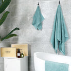 Aqua blue bath towel and hand towel hang on the walls of modern bathrooms