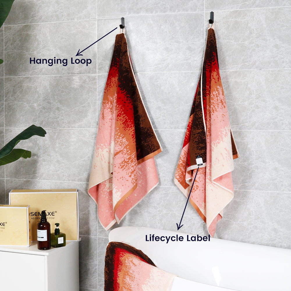 Two bath towels from the "Plum Garden" collection are hung on the bathroom wall with unique loops and lifecycle labels.