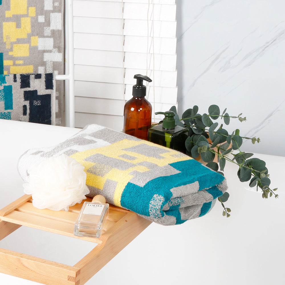 Bath towels from the Impression collection are folded and placed on the towel rack in the bathtub