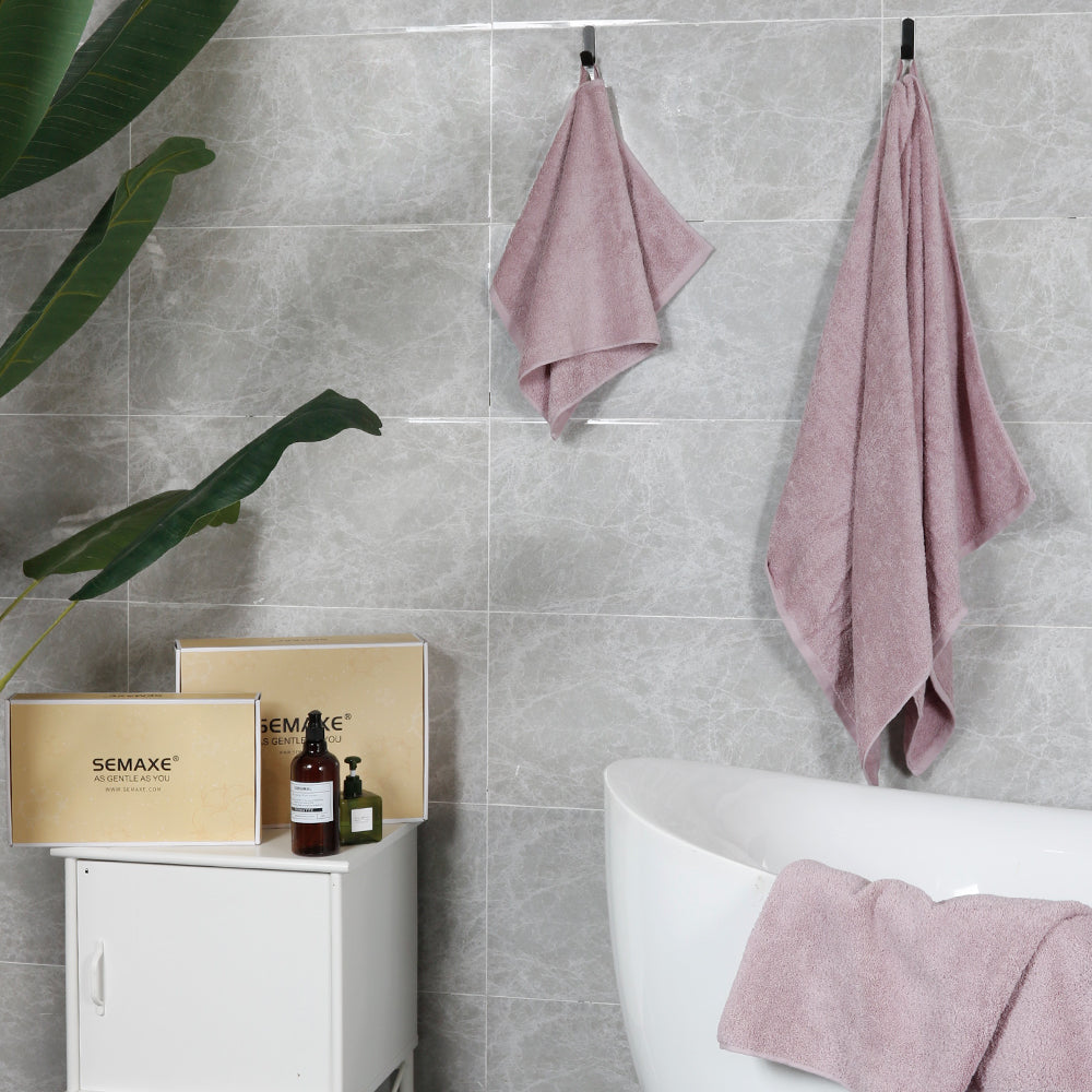 A purple towel hangs on the bathroom wall and shows off its gift box