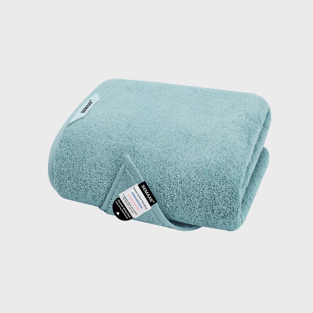 Light blue luxury bath towel from Semaxe, featuring plush cotton fabric with a detailed care label, ideal for enhancing bathroom comfort and style.