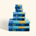 A 12-piece bath towel set, neatly arranged on a flat surface, with an artistic pattern inspired by Van Gogh's painting "Starry Night"