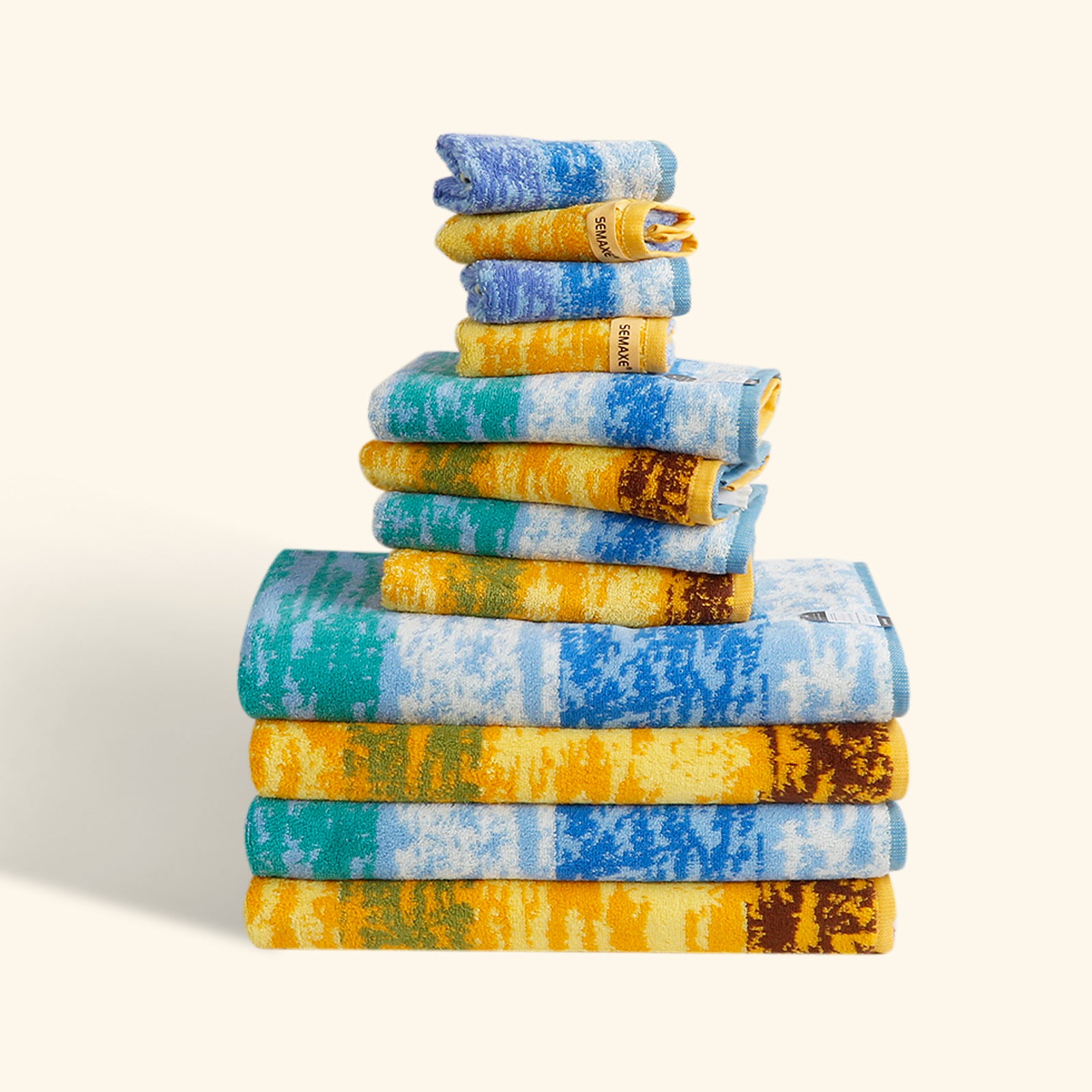 The 12-piece towel set is neatly arranged on a flat surface with rich artistic patterns on the towels