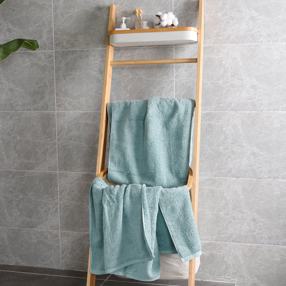 The aqua blue towel set hangs on the shelf