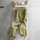 Green bath towels and hand towels are hanging on the shelves