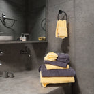 The yellow + gray mixed color towel set is placed on the cement wind wash basin