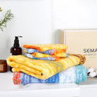 The "Wheat Field" bathroom towel set is placed on the sink, showing off its cotton and gift box packaging