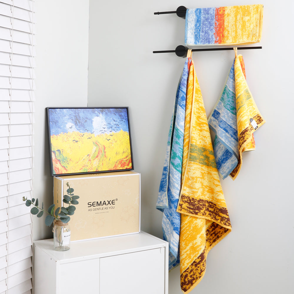 The bath towels, hand towels, and washcloths of the "Wheat Field" series are placed on towel rails, and their artistic patterns are inspired by Van Gogh's painting "Wheat Field with Crows"