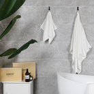 The modern bathroom is adorned with white bath towel and hand towel, while its unique gift box packaging is showcased